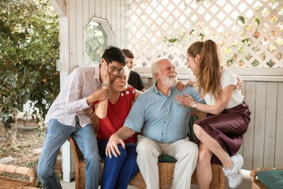 A multi-generational family together on a sunlit porch