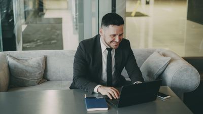 A professional working on a laptop in a modern office lounge