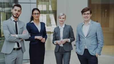 A team of professionals standing together in a modern office lobby