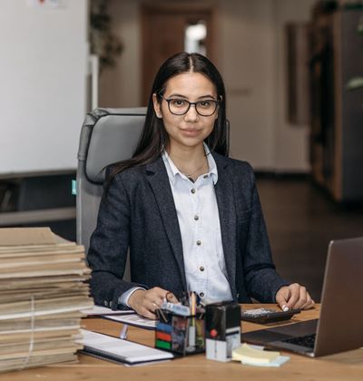 An entrepreneur working at her desk with a laptop and paperwork