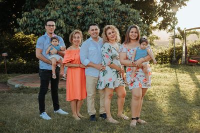 A multi-generational family posing together outdoors at sunset