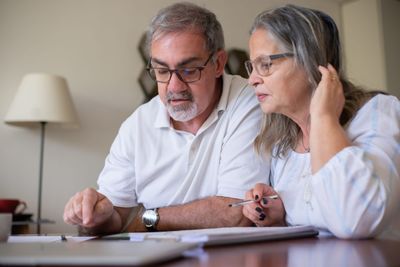 A couple reviewing financial paperwork together at home