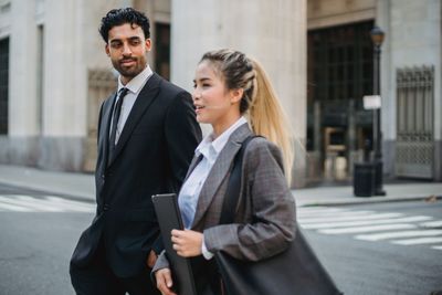 Two professionals walking together on a city street